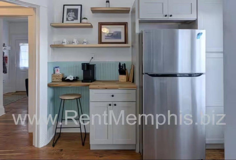 Kitchen featuring freestanding refrigerator, wood counters, open shelves, dark wood-style floors, and white cabinets