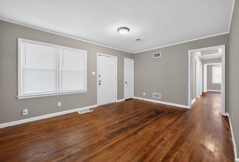Foyer entrance with dark wood-style flooring and crown molding