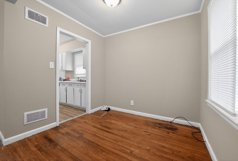 Empty room with hardwood / wood-style floors and crown molding