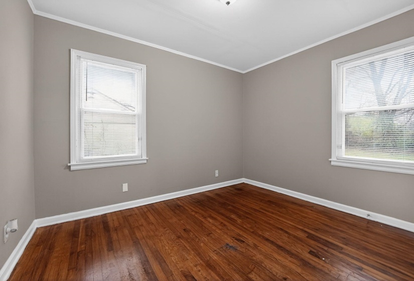 Empty room with dark wood finished floors and ornamental molding