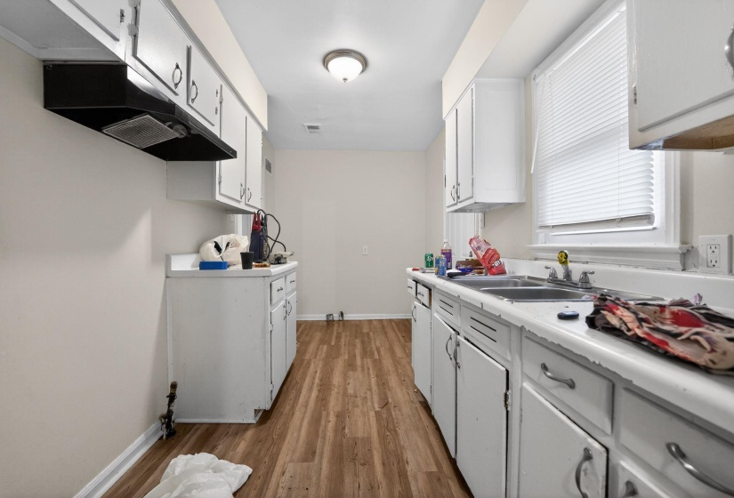 Kitchen with light countertops, light wood-style flooring, and white cabinets