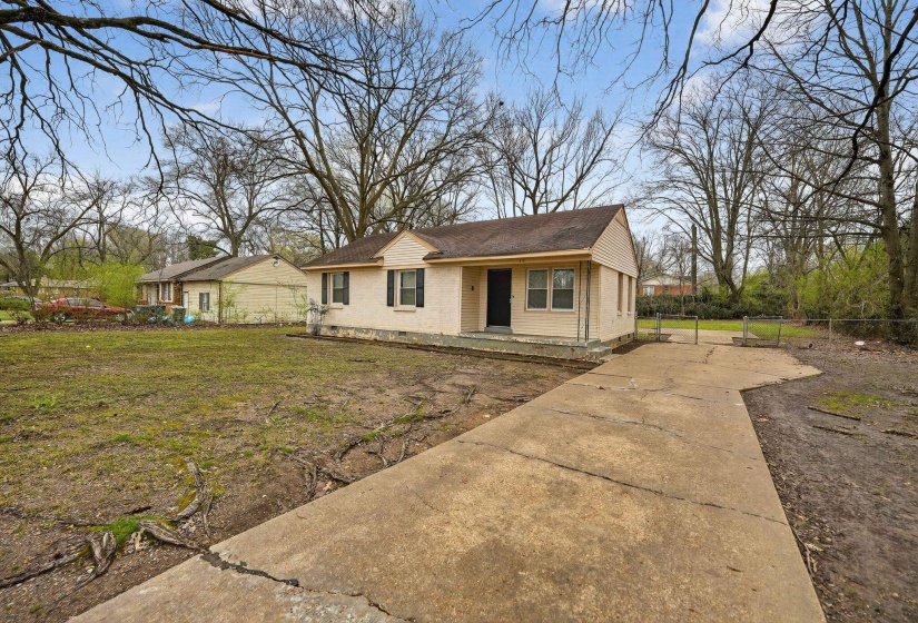 View of front of house featuring concrete driveway and brick siding