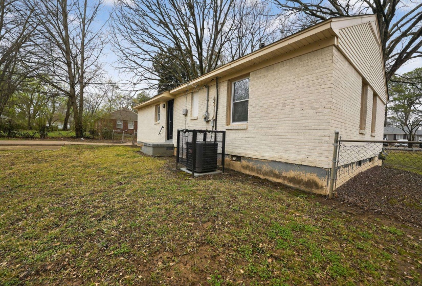 View of side of home with brick siding and crawl space
