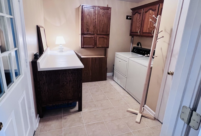 Laundry room with cabinet space, light tile patterned floors, and independent washer and dryer