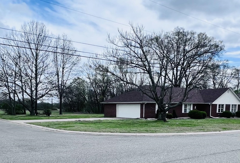 View of front of property featuring brick siding, a front yard, a garage, and concrete driveway