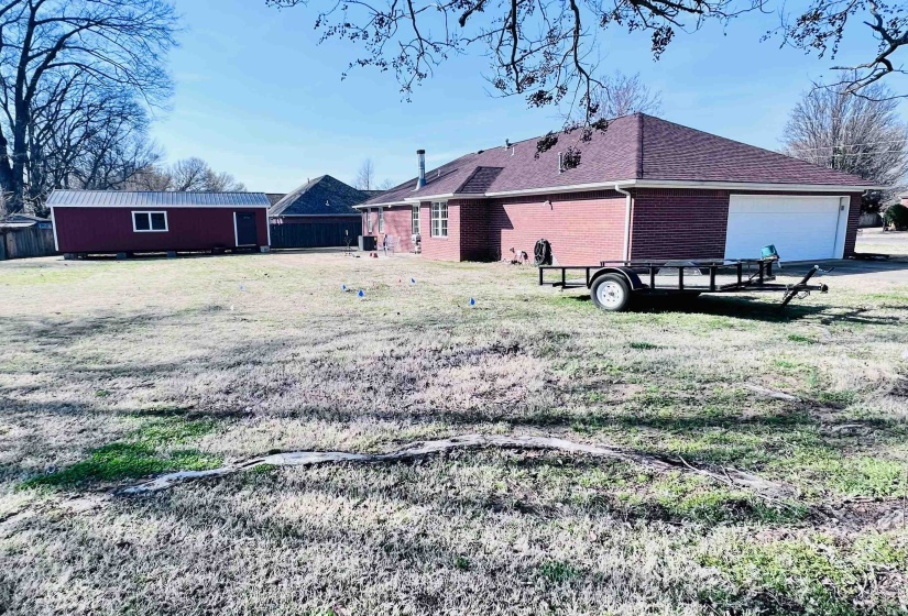 Rear view of property featuring brick siding, a shingled roof, and an attached garage