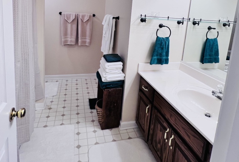 Bathroom with vanity, light floors, and curtained shower
