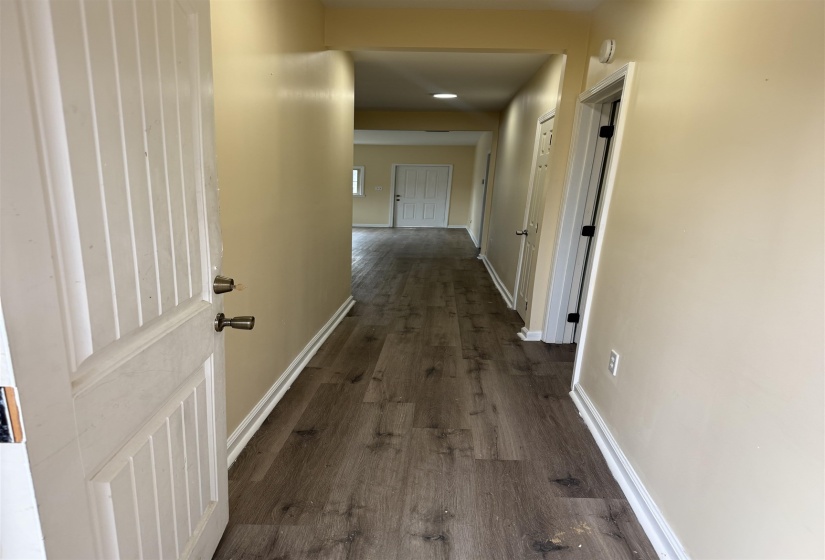 Hall with dark wood finished floors and baseboards