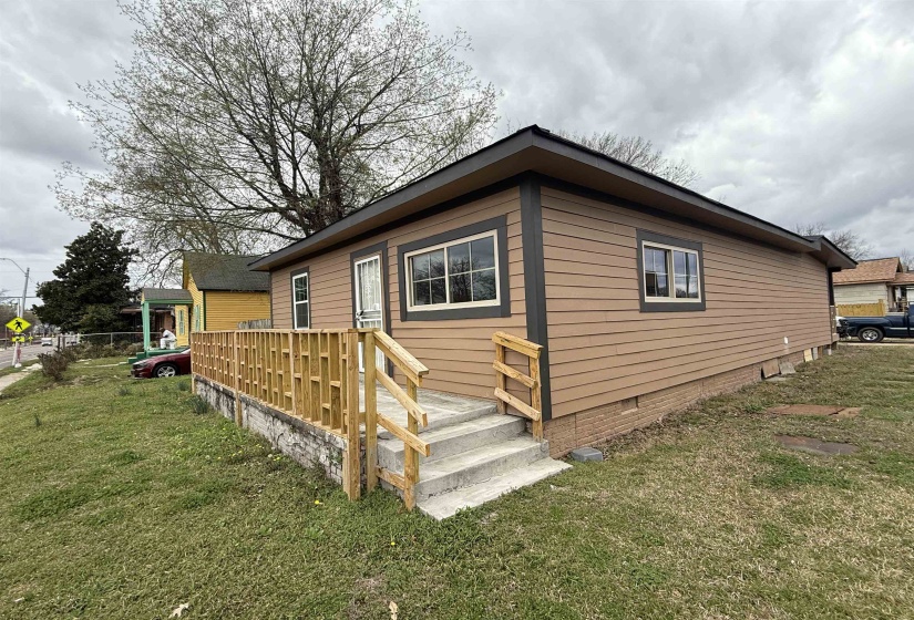 View of side of property with crawl space and a lawn