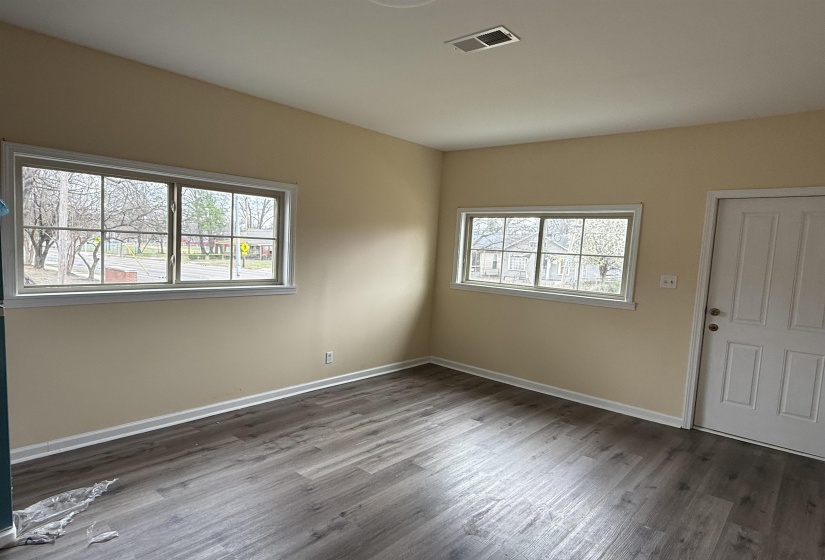 Empty room featuring plenty of natural light and dark wood-type flooring