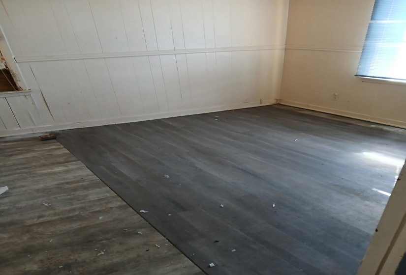 Spare room featuring dark wood-style flooring and wooden walls