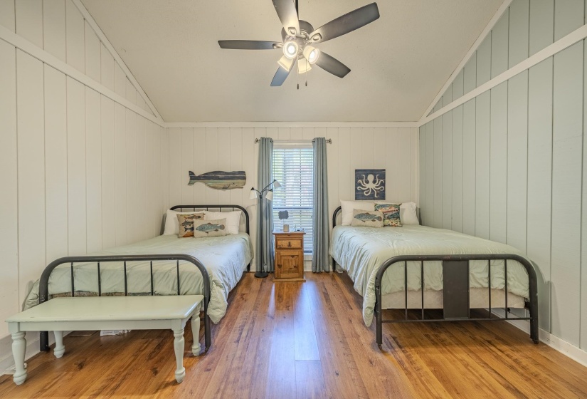 Vaulted ceiling room featuring hardwood flooring and a ceiling fan with light fixture