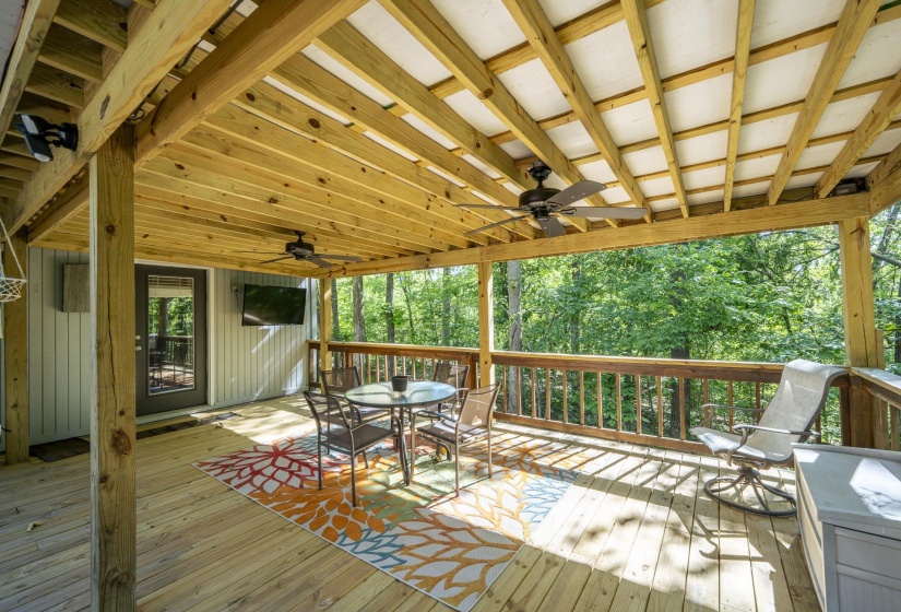 Expansive wooden deck featuring exposed beam ceiling, recessed lighting, and a ceiling fan