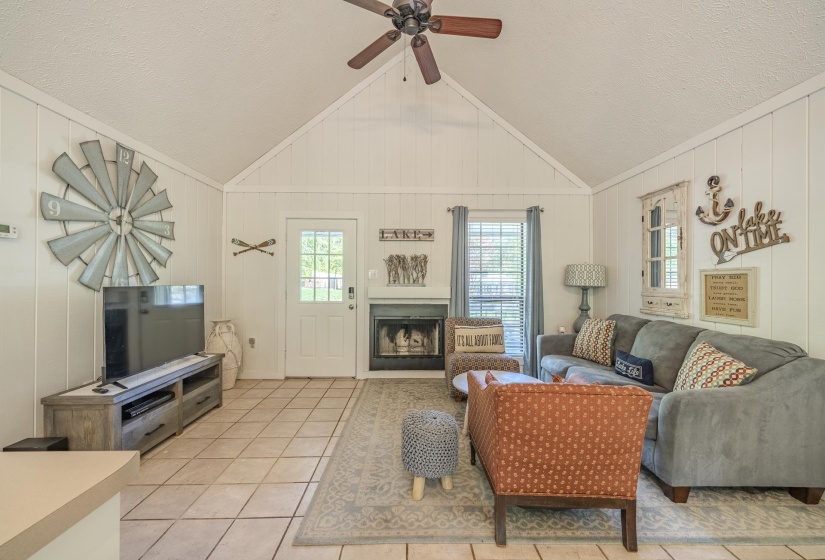 Vaulted ceiling with wood-paneled walls and a ceiling fan