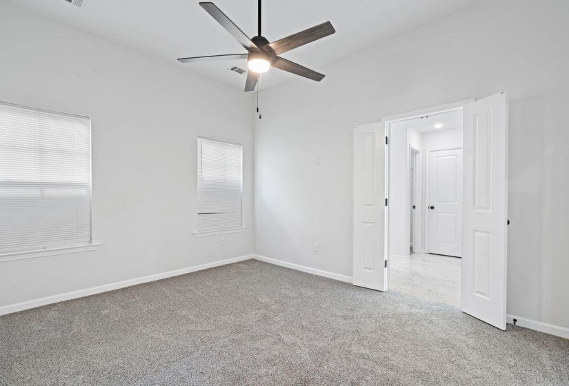 Unfurnished bedroom featuring light colored carpet and a ceiling fan