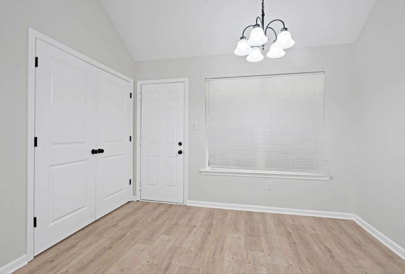 Unfurnished dining area with light wood-style flooring, vaulted ceiling, and a chandelier