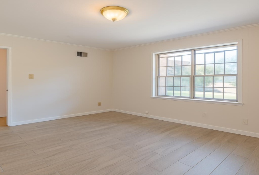 Unfurnished room with light wood-type flooring, crown molding, and baseboards