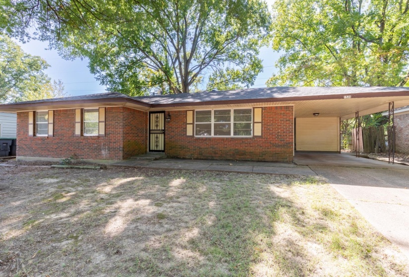Single story home with brick siding, a carport, and concrete driveway