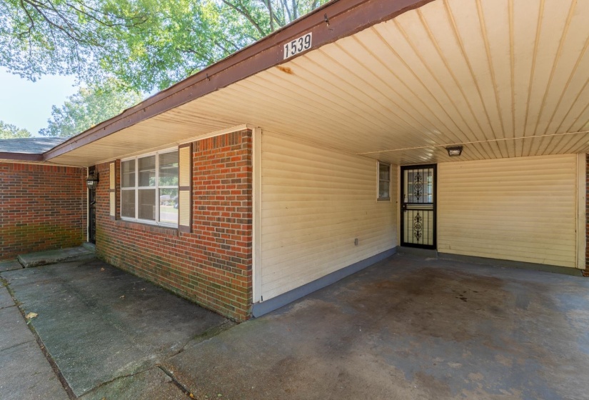 View of home's exterior with brick siding and a carport