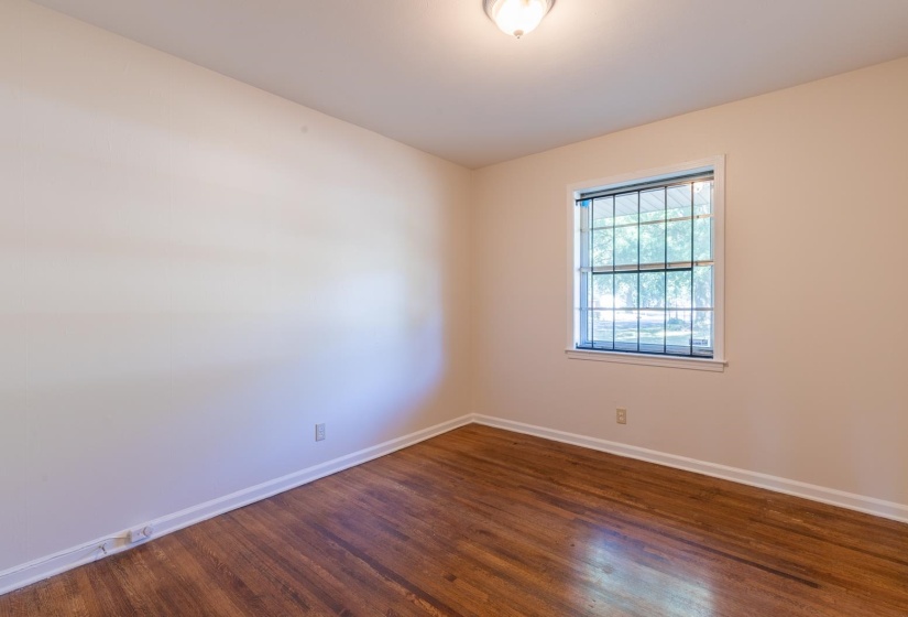 Spare room with dark wood-style flooring and baseboards
