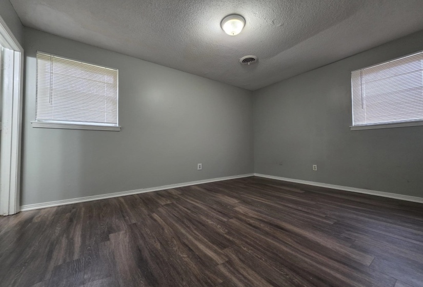 Unfurnished room featuring a textured ceiling and dark wood-type flooring