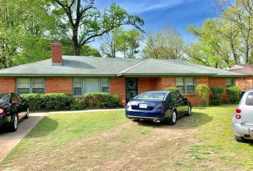 Ranch-style house featuring a chimney, brick siding, and a front yard