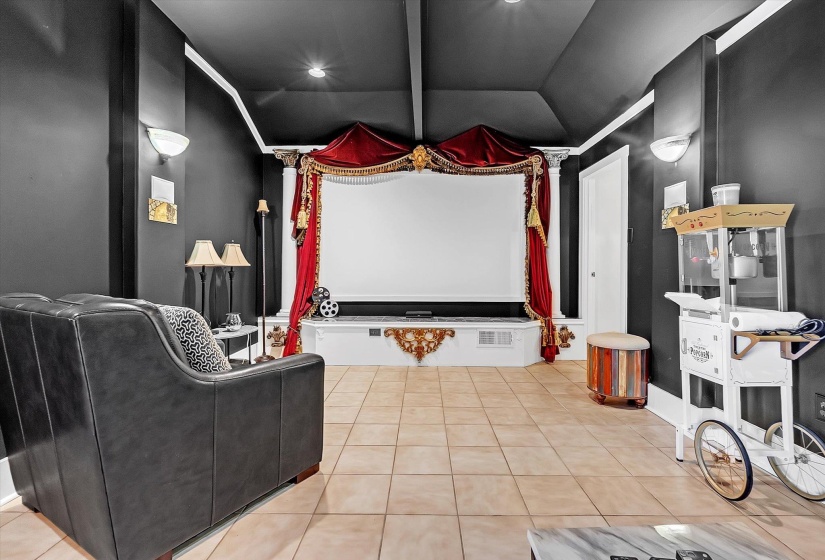 Cinema with lofted ceiling with beams and light tile patterned floors