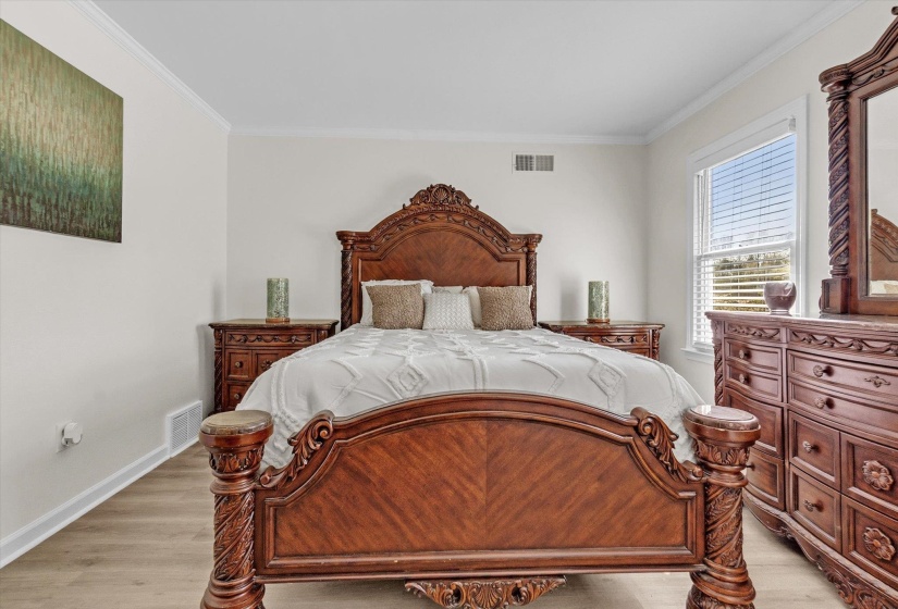Bedroom with ornamental molding and light wood-type flooring