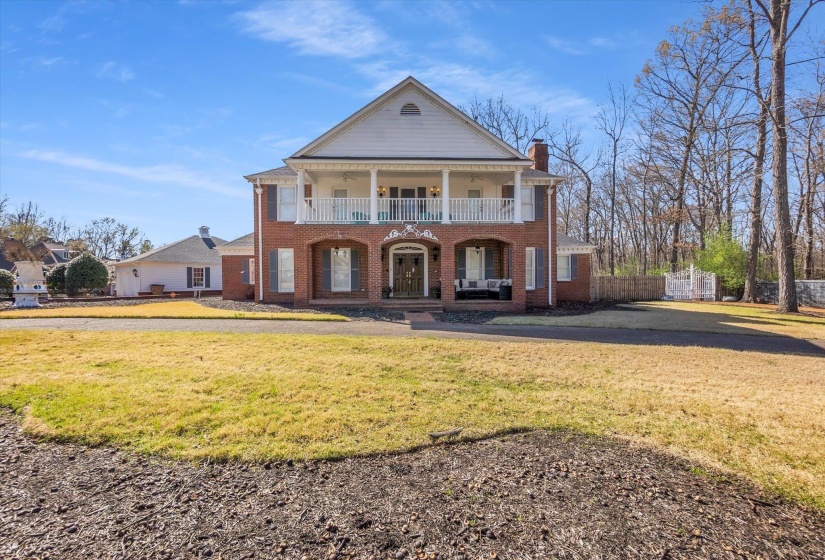 View of front facade featuring covered porch, brick siding, and a chimney