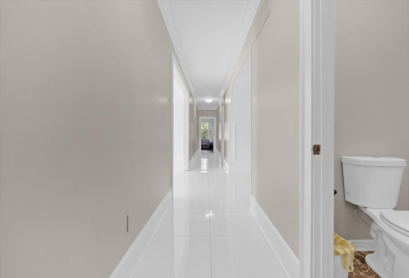Hallway with light tile patterned floors and crown molding
