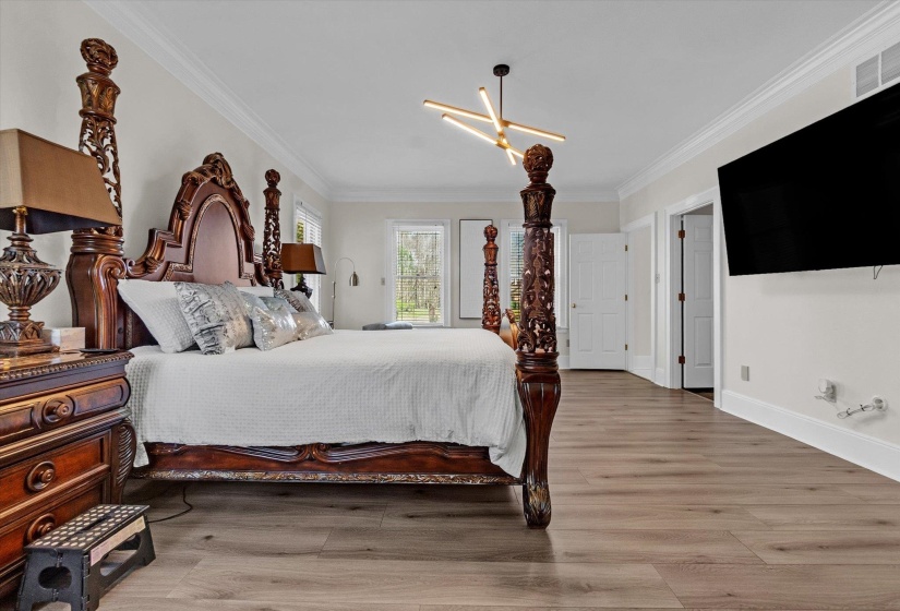 Bedroom with light wood finished floors and ornamental molding