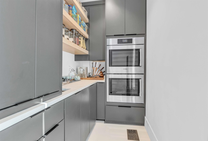 Kitchen with gray cabinets, stainless steel double oven, modern cabinets, and light countertops