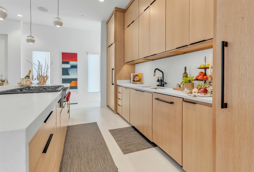 Kitchen featuring light wood finish cabinetry, modern cabinets, decorative light fixtures, and stainless steel gas cooktop