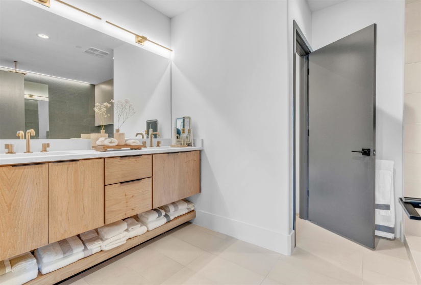Full bathroom with double vanity, light tile patterned floors, recessed lighting, and a shower
