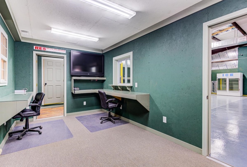 Home office with light carpet and built in study area