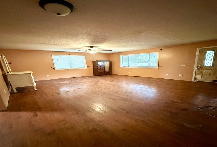 Unfurnished living room featuring wood finished floors and a textured ceiling