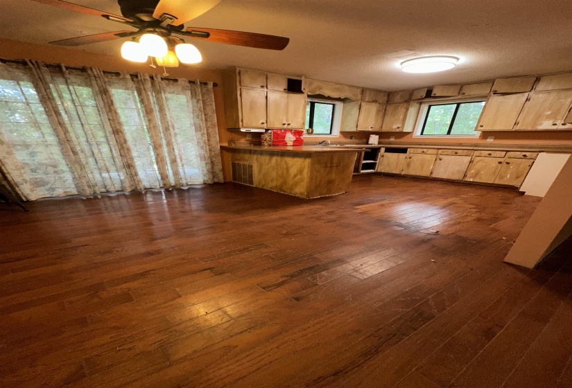 Kitchen featuring a peninsula, dark wood finished floors, a ceiling fan, and a textured ceiling