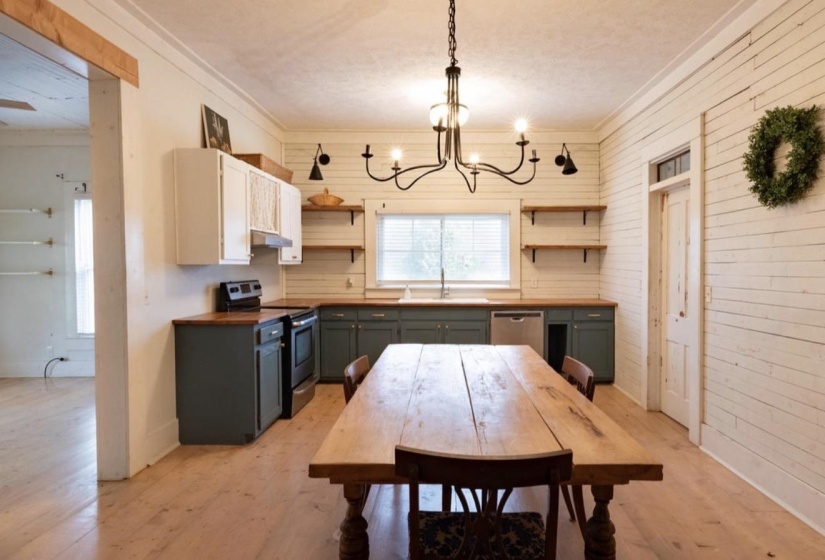 Dual tone kitchen featuring wooden counters, stainless steel appliances, light wood-type flooring, crown molding, and open shelves