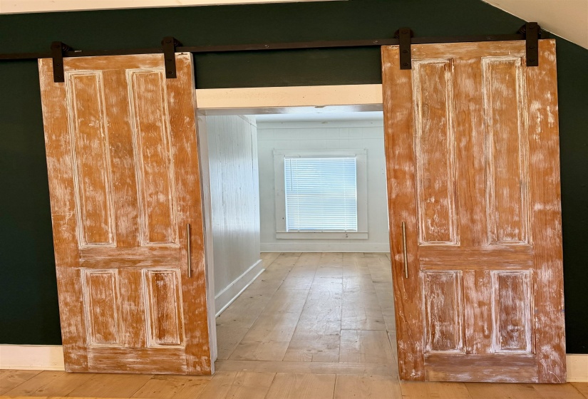 Hallway featuring a barn door and light wood-style floors