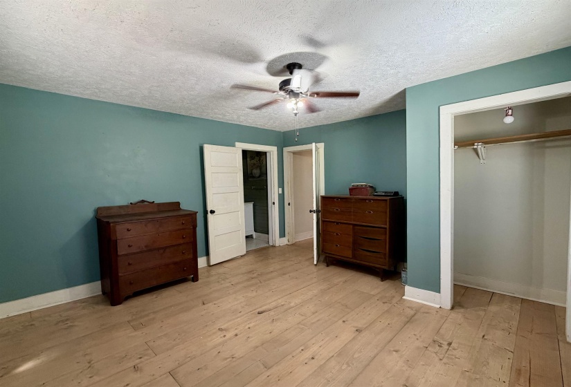 Bedroom featuring light wood-style flooring, a ceiling fan, a closet, and a textured ceiling