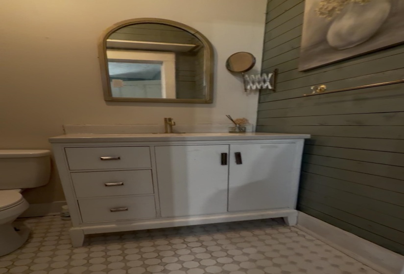 Bathroom featuring vanity, wood walls, and light flooring