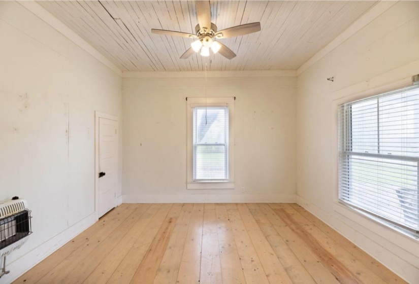 Empty room with light wood-type flooring, ceiling fan, wooden ceiling, heating unit, and ornamental molding