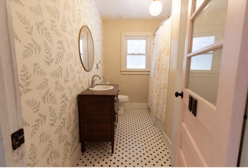 Full bathroom featuring a shower with curtain, vanity, and wallpapered walls