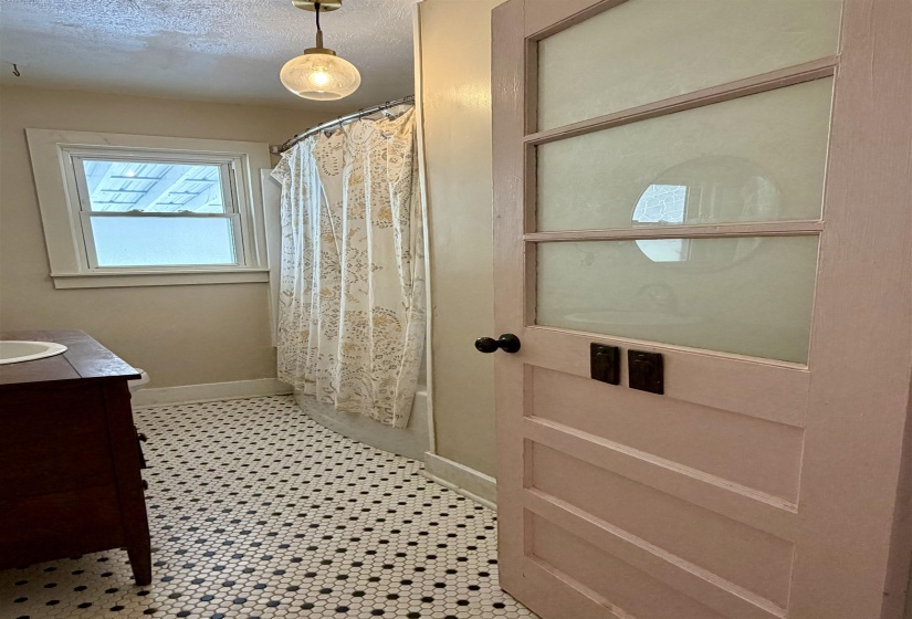 Full bathroom with vanity, a textured ceiling, and shower / bath combo