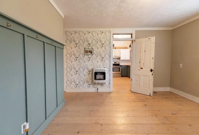 Unfurnished living room featuring light wood-style floors, heating unit, a textured ceiling, and electric panel