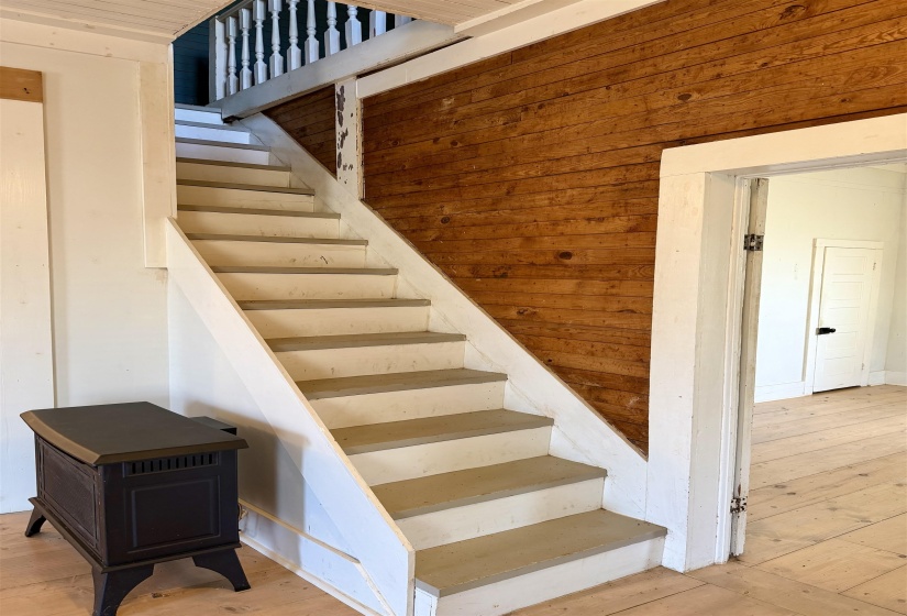 Stairway with hardwood / wood-style floors and wood walls