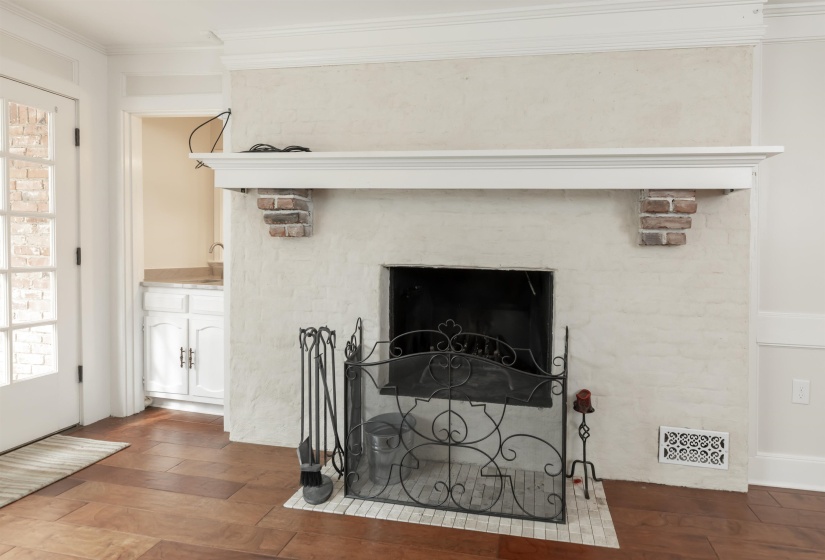 Detailed view of ornamental molding, wood finished floors, and a fireplace with flush hearth