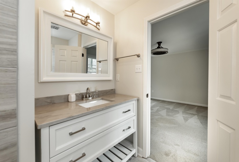 Bathroom featuring vanity and light carpet