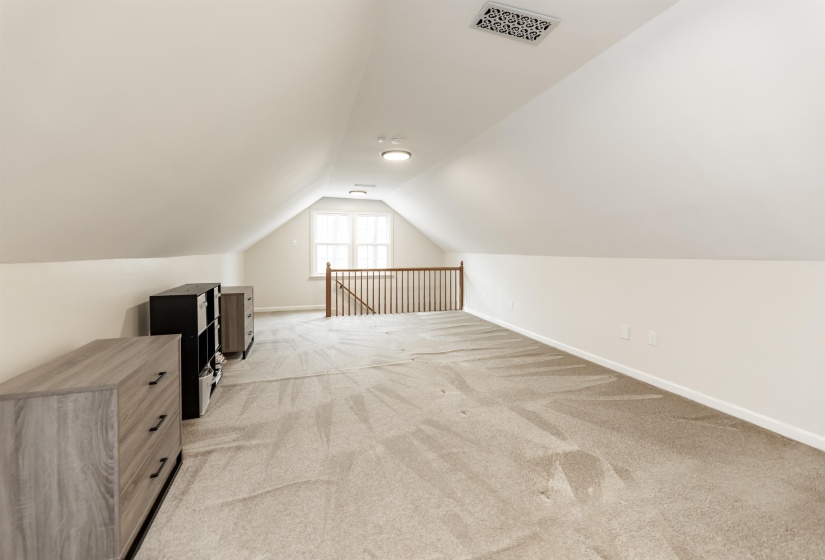 Bonus room with baseboards and light carpet