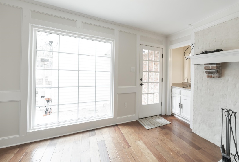 Doorway featuring wood finished floors, ornamental molding, and a decorative wall